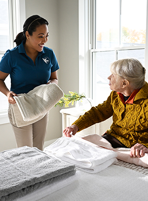 A Visiting Angels caregiver patiently listening to an elderly man with dementia, emphasizing the importance of communication and support.