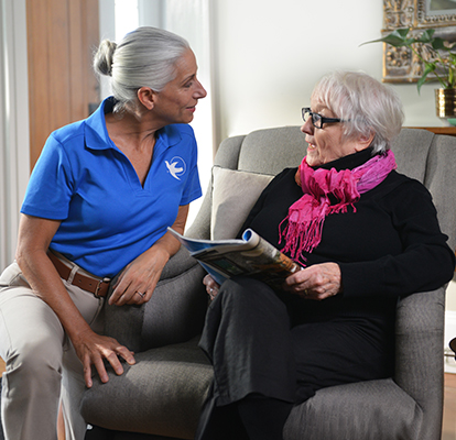 A Visiting Angels caregiver comforting an elderly woman with Alzheimer's, highlighting compassionate support in a peaceful home setting.